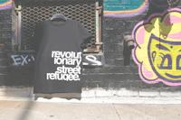 a black t - shirt that says revoltionary street refugee