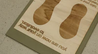 a wooden sign with a pair of shoes on it